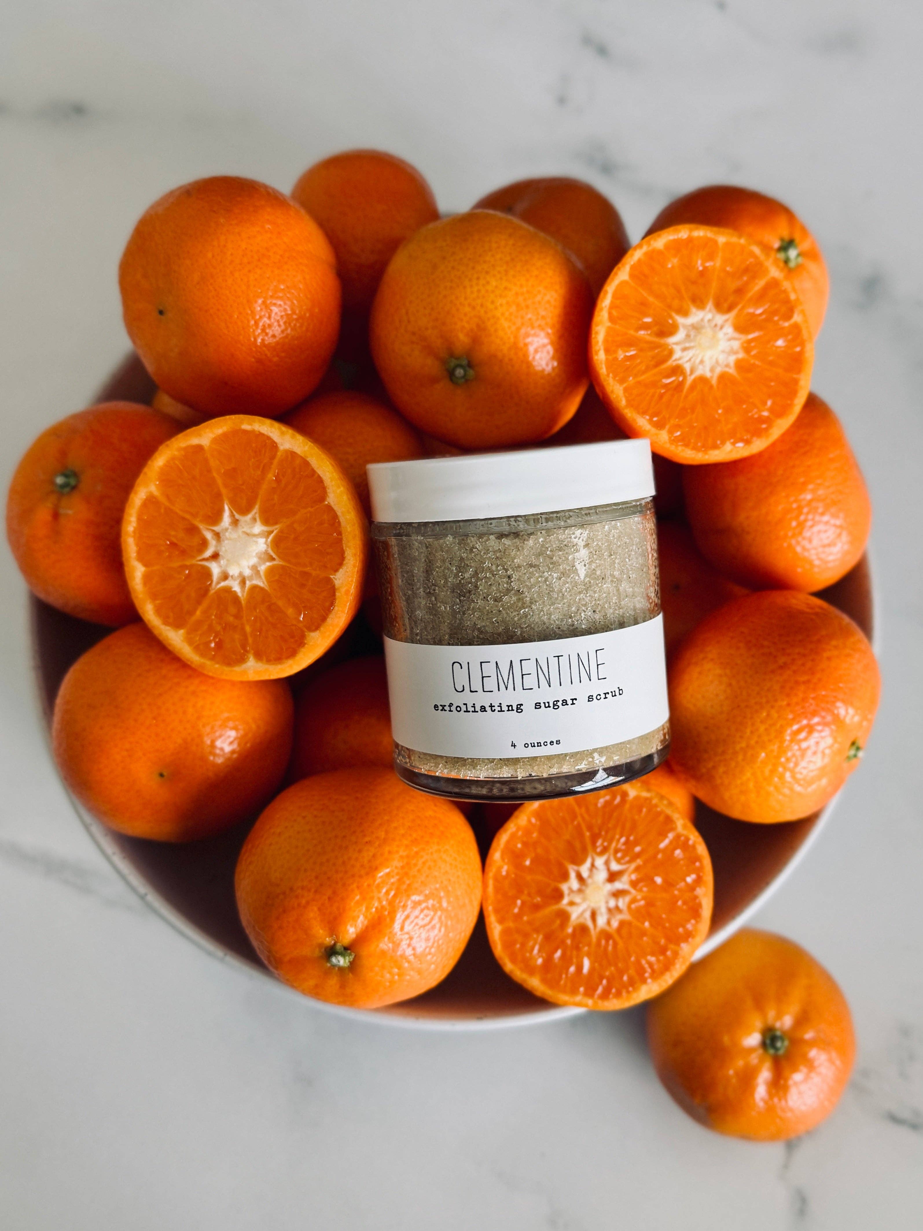 Clementine sugar scrub in a bowl with clementines on a marble surface